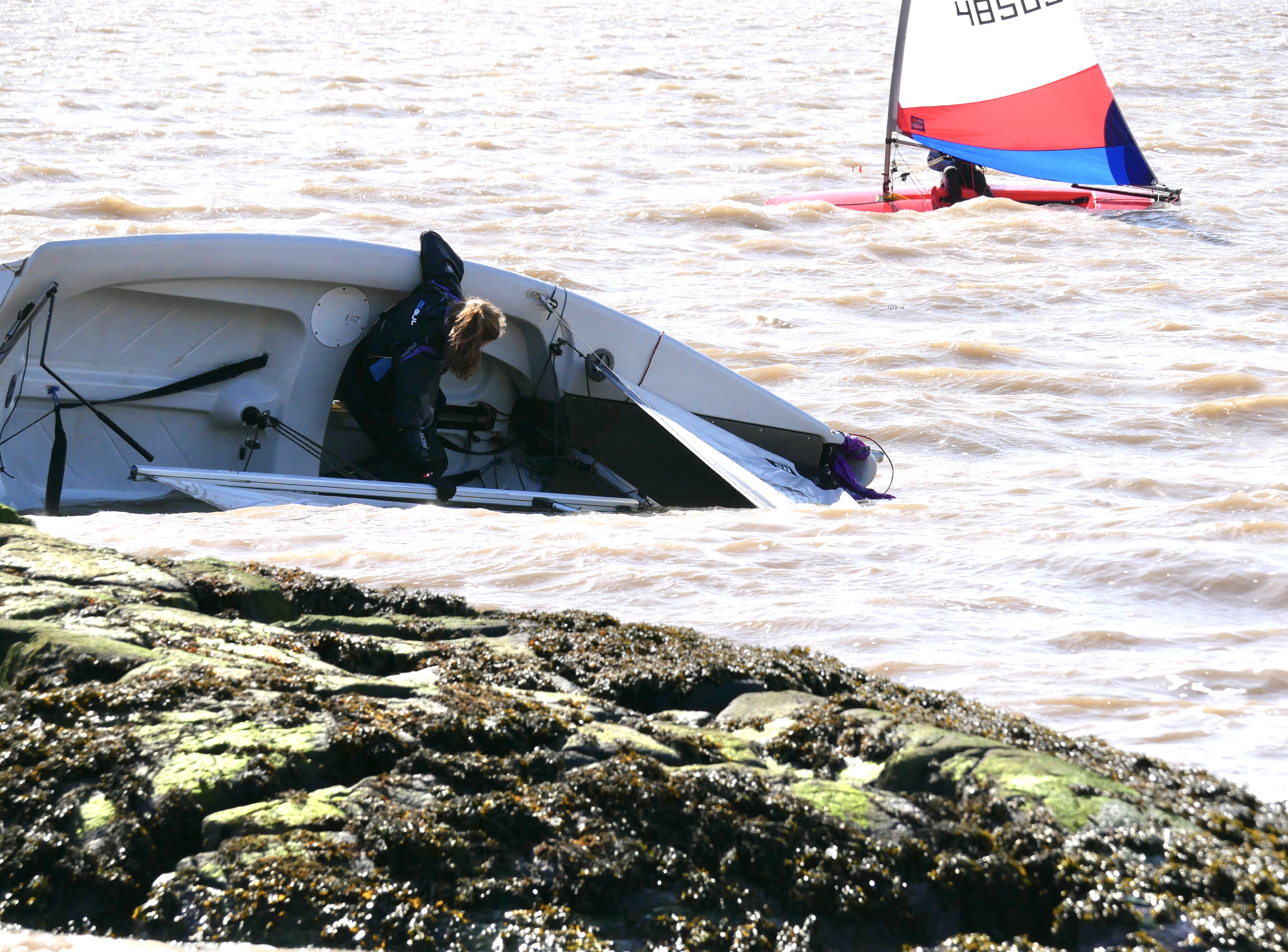 James Bishop and Noa Crowley in a bit of bother near the rocks while Lucy Leyshon sails on to her 4th overall in the series